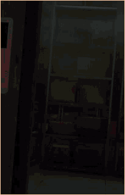 a red light is lit up in a dark room with a yellow sign in the background