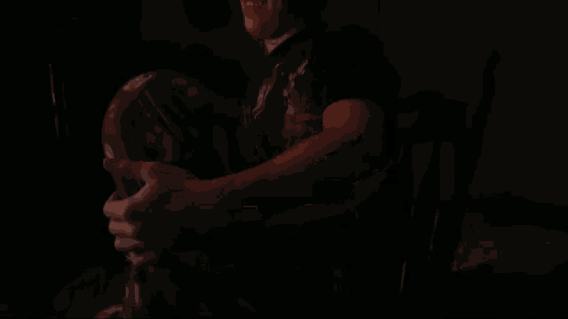 a person sitting in a dark room with a cat sticker on a yellow box