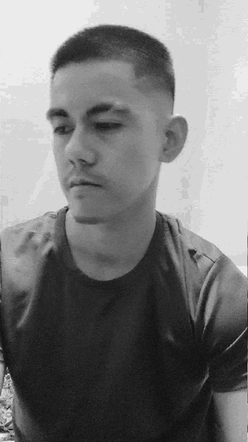 a black and white photo of a man wearing a t-shirt