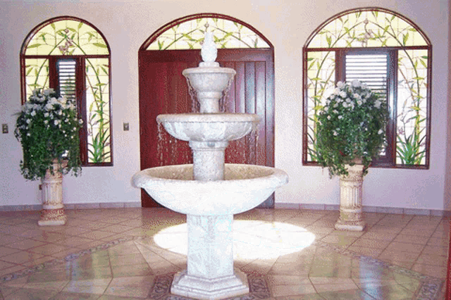 a fountain in a room with a stained glass window