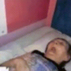 a blurry picture of a person laying on a bed with a tie around their neck