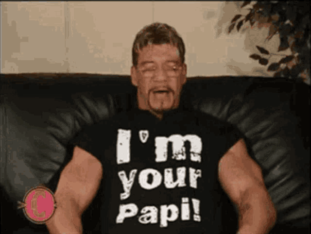 a man sitting on a couch wearing a shirt that says i 'm your papi