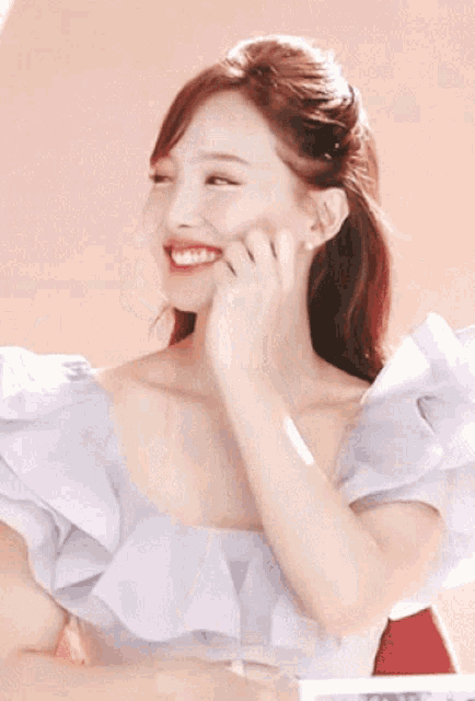 a woman in a white dress is making a face with her hands