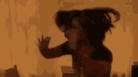 a woman in a black shirt is dancing in a room .