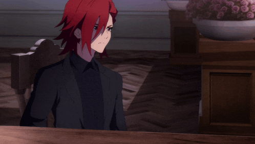 a man with red hair sits at a table