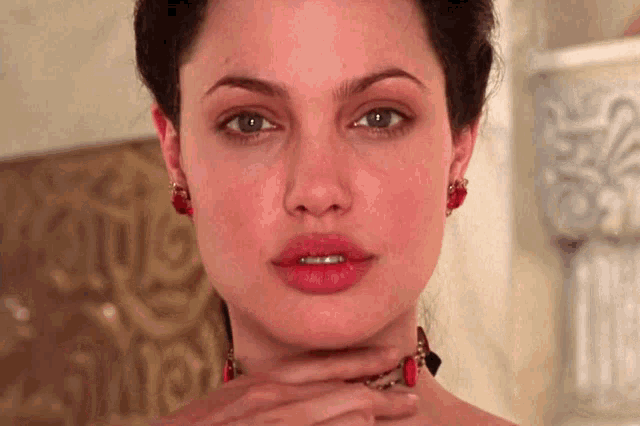 a close up of a woman 's face with her hand on her chin