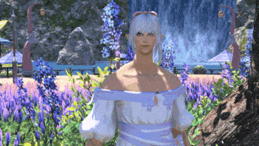 a woman in a white dress stands in front of a waterfall