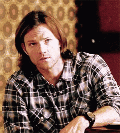 the man is wearing a plaid shirt and a watch