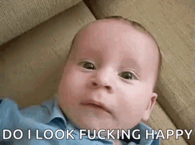 a baby is laying on a couch with the words `` do i look fucking happy '' written on it .