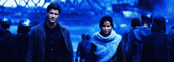 a man and a woman are walking through a crowd of people in a city .