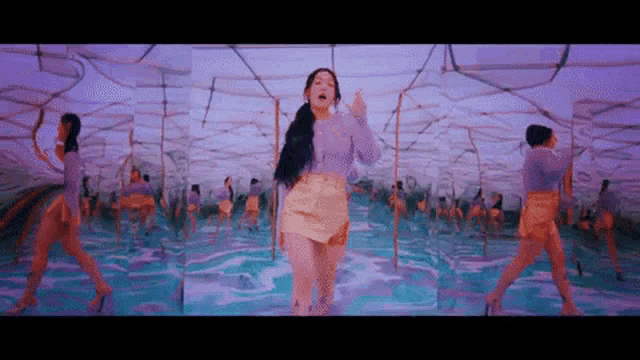 a woman in a purple top and a yellow skirt is standing in a pool of water .