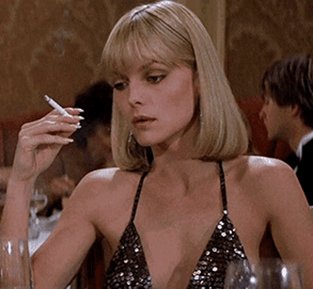 a woman in a sequined top is smoking a cigarette in a restaurant