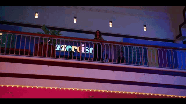 a woman stands on a balcony overlooking a store called exercise
