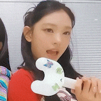 a girl in a red shirt is holding a white object with a butterfly on it