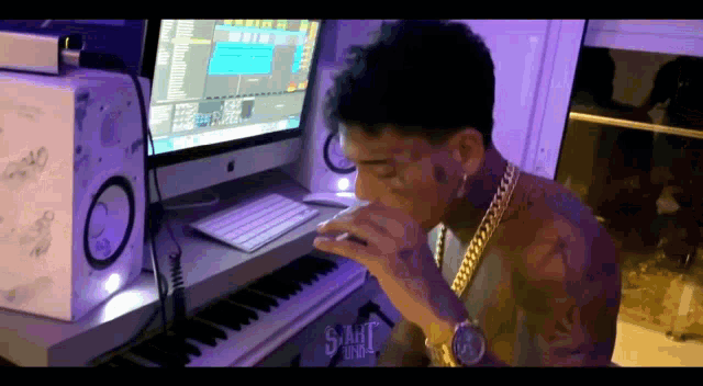 a man is sitting at a desk with a computer and a keyboard and the word sanat on the bottom