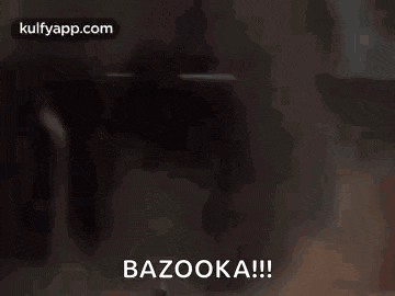 a man is holding a bazooka in his hands while sitting in a vehicle .