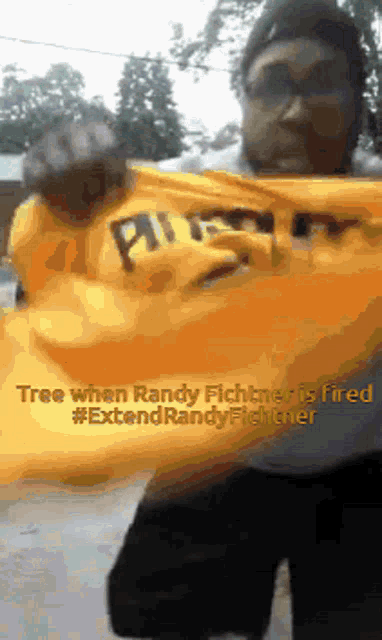 a man is holding a yellow shirt that says pittsburgh on it