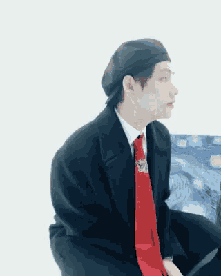 a man in a suit and tie is sitting on a couch with a knife in his hand .