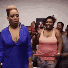 two women are standing next to each other in a crowd .