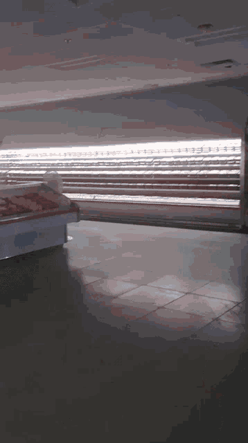 an empty grocery store with a display case full of meats