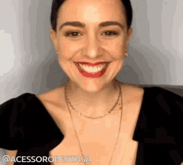 a woman wearing a black top and red lipstick is smiling with the words @acessorobertasa on the bottom