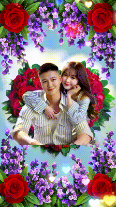 a man and a woman are posing for a picture surrounded by purple and red flowers