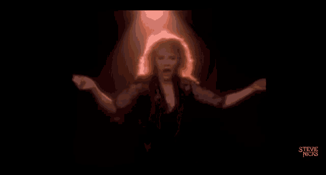 a blurred image of a person holding a microphone in a dark room with the words steve nicks on the bottom