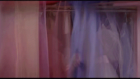 a woman in a red dress and yellow top is standing in a closet