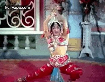 a woman in a costume is dancing on a red carpet .