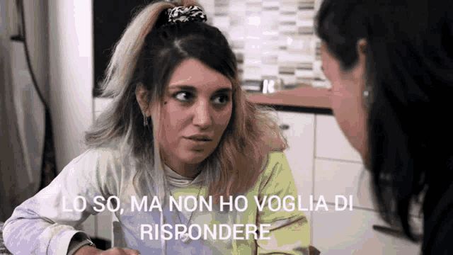 a woman is talking to another woman and the words lo so ma non ho voglia di rispondere are on the screen