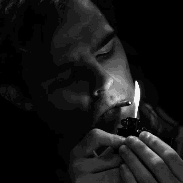 a man is lighting up a cigarette with a zippo lighter