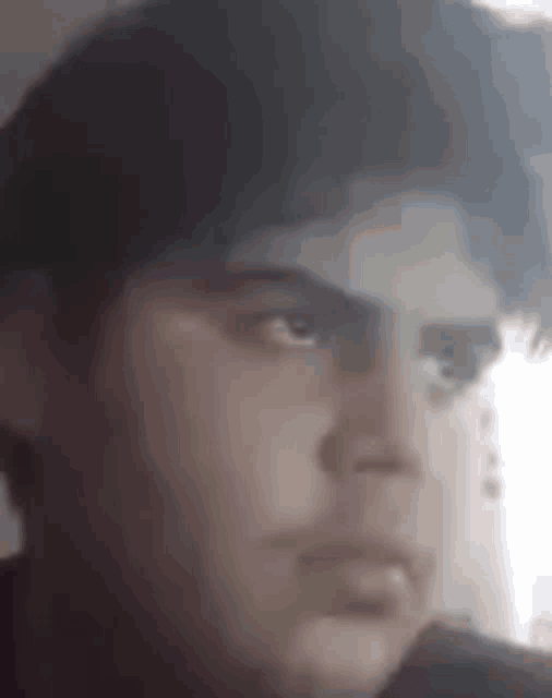 a close up of a man 's face in a blurry photo .