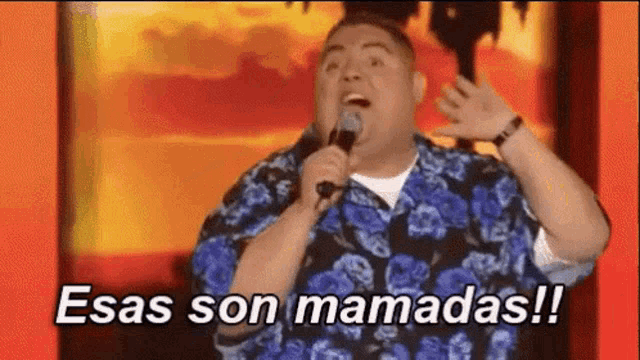 a man is singing into a microphone with the words " esas son mamadas " written below him