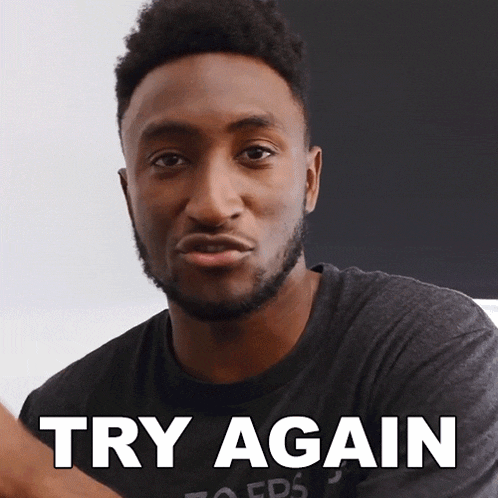 a man wearing a black shirt with the words try again on it