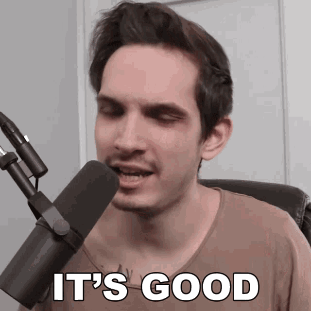 a man speaking into a microphone with the words it 's good written below him