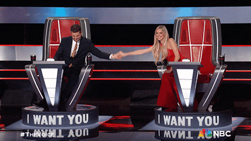 a man and a woman shaking hands in front of a sign that says i want you