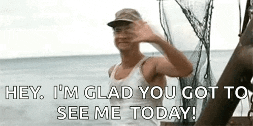 a man is waving at the camera while standing on a boat .