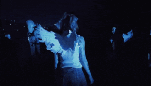 two people are dancing in a dark room and one of them has wings on