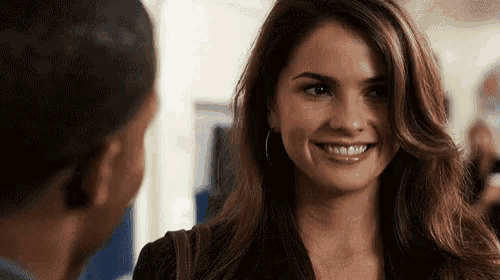 a woman is smiling and looking at a man .