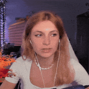 a woman wearing headphones and a necklace is sitting in front of a computer .