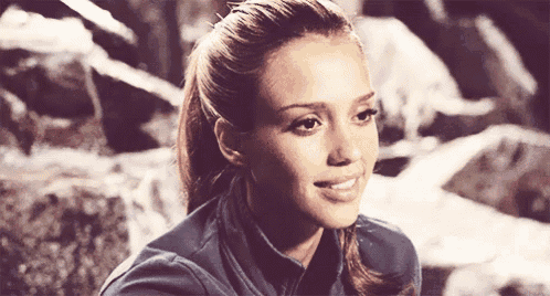 a close up of a woman 's face with a ponytail