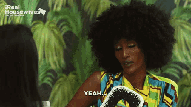 a woman with an afro says yeah in front of a palm tree wallpaper