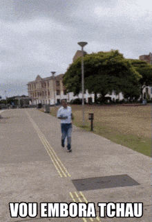 a man running down a sidewalk with the words vou embora tchau