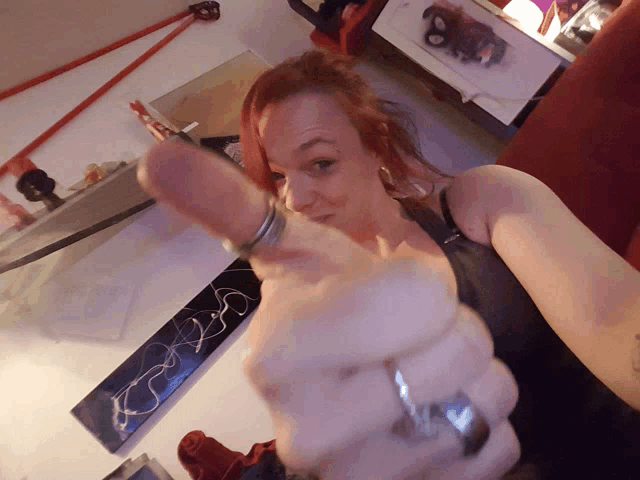 a woman with red hair is pointing her finger