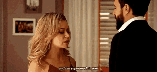a man and a woman are talking to each other in a room .