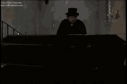 a man in a tuxedo is laying on a couch with candles in the background