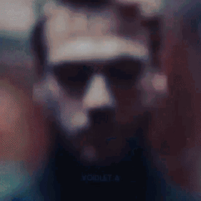 a blurry picture of a man wearing sunglasses with the word violet visible in the corner