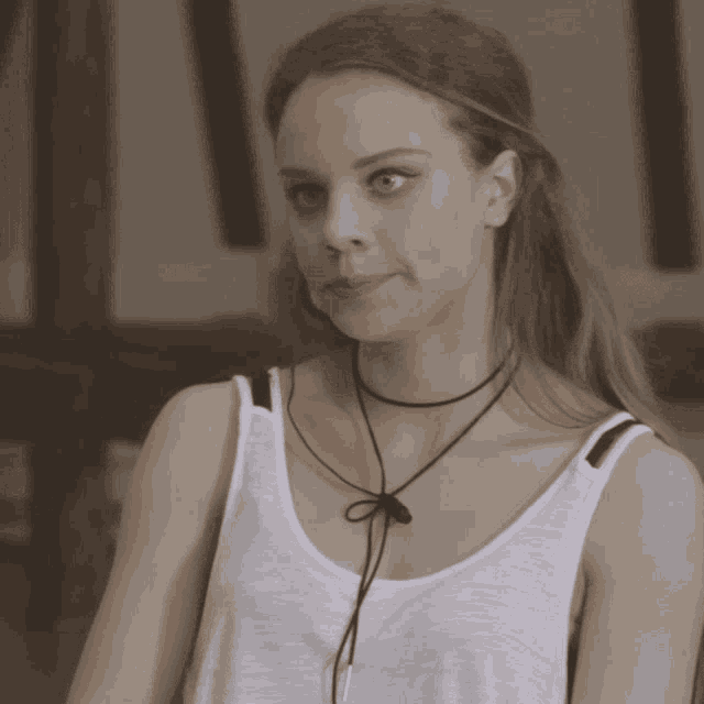 a woman wearing a white tank top and a black choker necklace