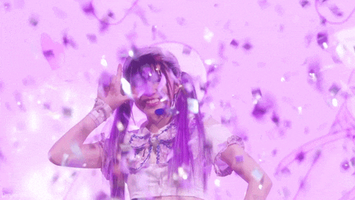 a girl with purple hair is standing in front of a pink background with confetti falling on her