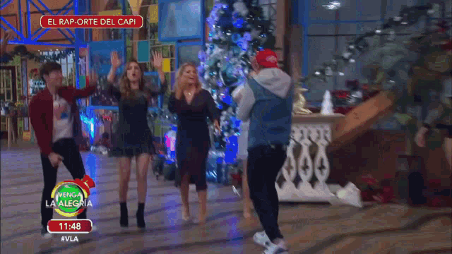 a group of people are dancing in front of a sign that says el rap - orte del capi
